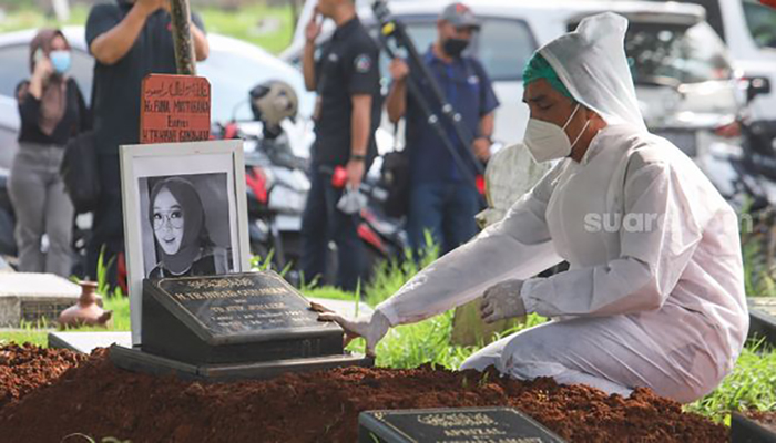 Suami mendiang Presenter Rina Gunawan, Teddy Syah berdoa di atas pusara sang istri saat prosesi pemakaman di TPU Tanah Kusir, Jakarta Selatan, Rabu (3/3/2021). [Suara.com/Alfian Winanto]