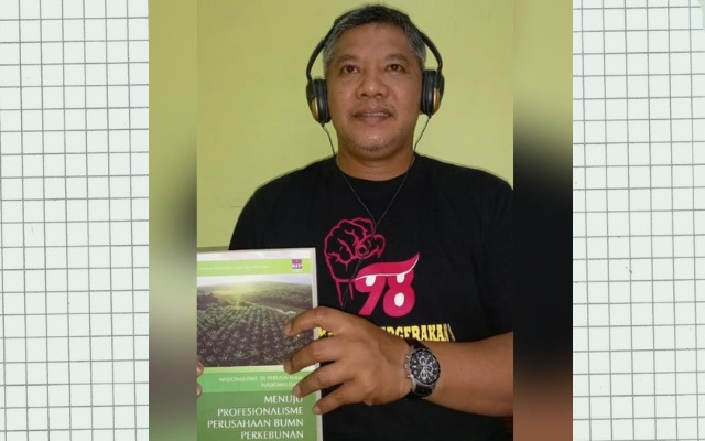 Aktivis 98 Sahat Simatupang tengah memegang Buku Karya Christian Orchard Perangin - angin, yang berjudul Nasionalisme Di Perusahaan Nasionalisasi Menuju Profesionalisme BUMN Perkebunan